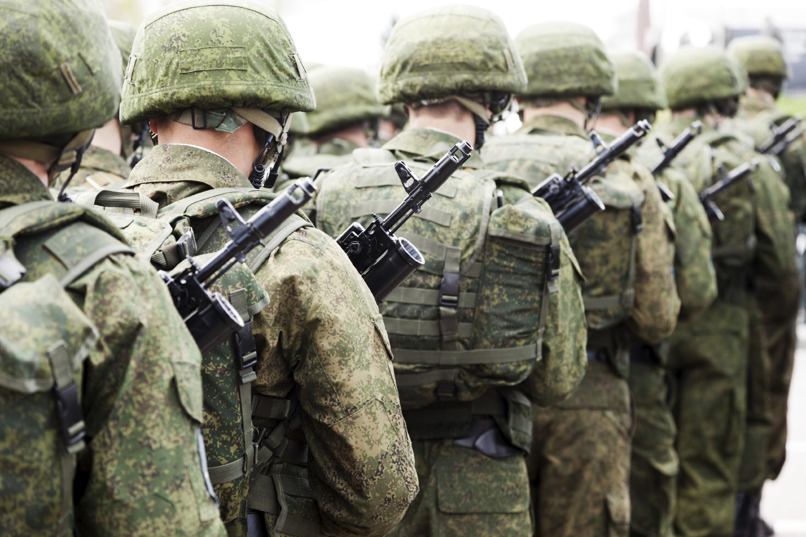 soldiers wearing battle dress uniforms march in formation