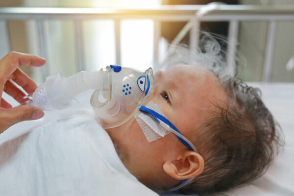 Young Child Wrapped In A Blanket Receives Nebulizer Treatment