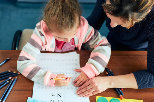 Preschool Child Doin Homework With An Adult.