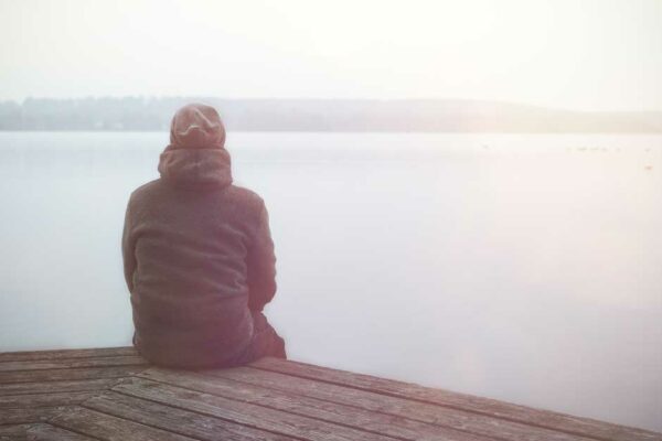 Man Sits Alone On A Dock