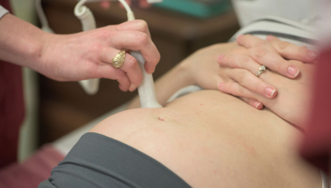 ultrasound technician wearing an Aggie ring performs a prenatal ultrasound