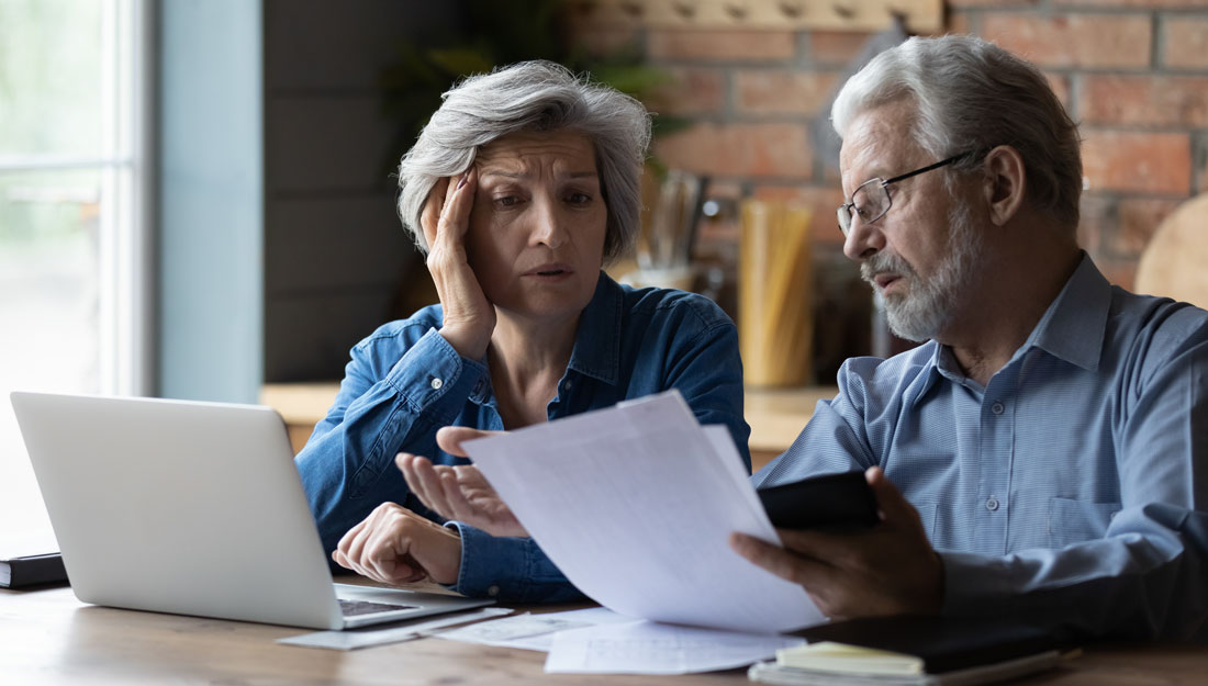 older couple looks worried over paying bills