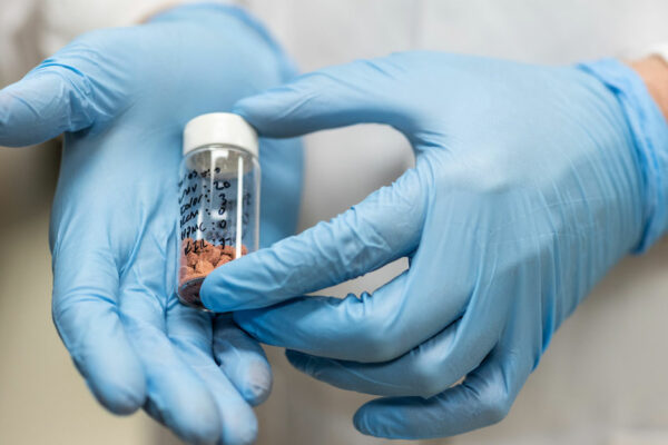 Lab Worker Holds A Vial Filled With 3D Printed Pills