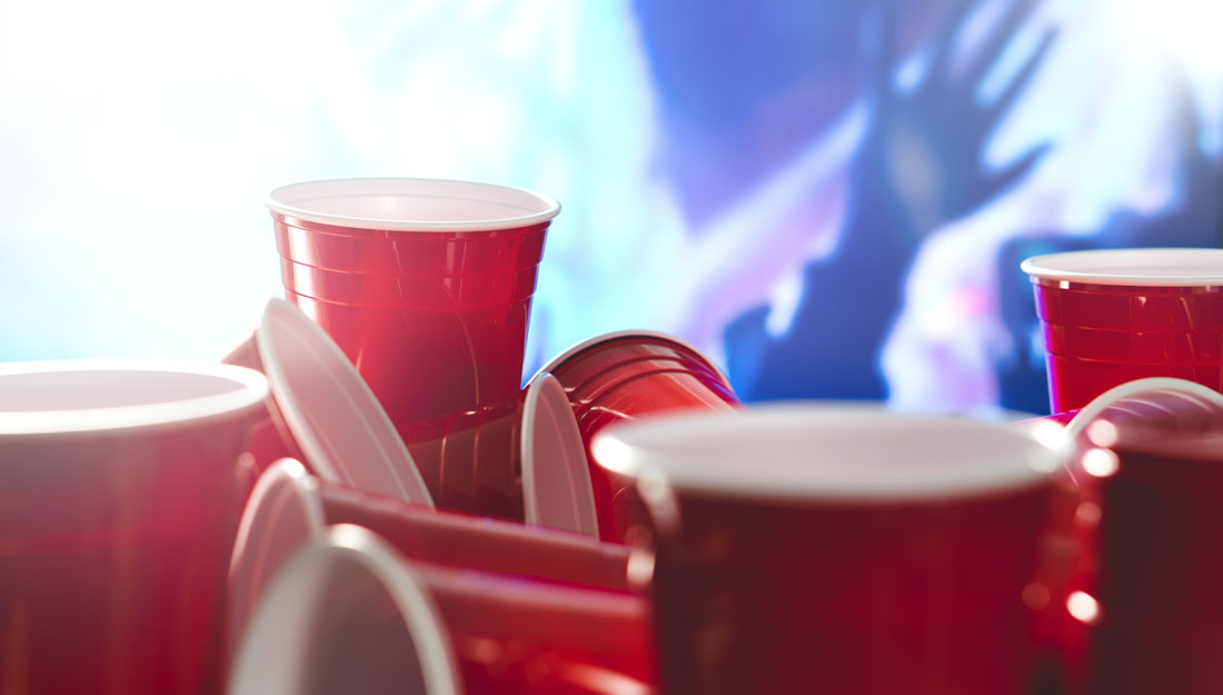 many red solo cups with party blurred in the background