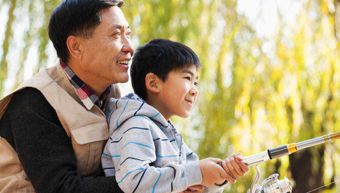 Men's health tip image, showing a boy fishing while his father holds him.