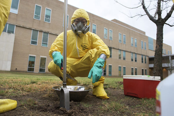 Field Researcher Wears Hazmat Suit While Collecting Soil Samples