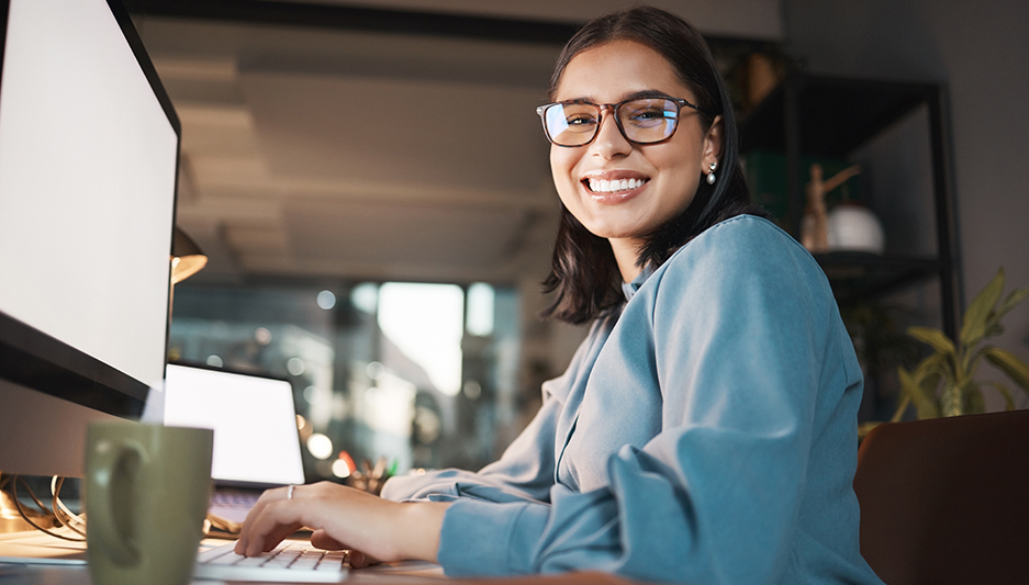 smiling woman works on a computer in a non-traditional work environment, flexible work arrangement