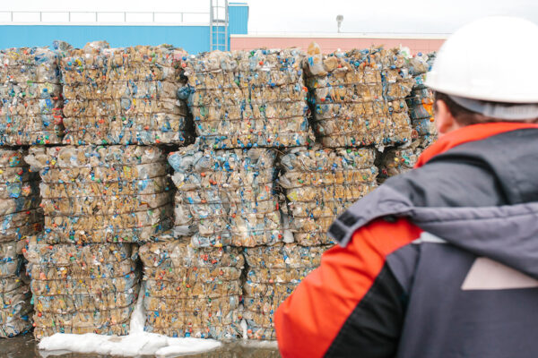 Waste Processing Plant. Technological Process For Acceptance, Storage, Sorting And Further Processing Of Waste For Their Recycling. Selective Focus. The Worker Is Out Of Focus Or Blurred.