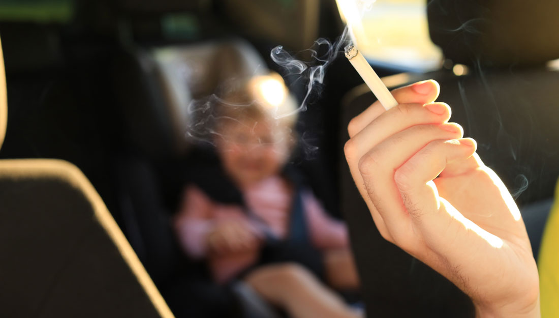 woman with cigarette and child in car