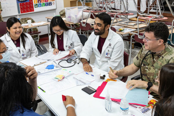 Students And Health Professions At A Table Talking