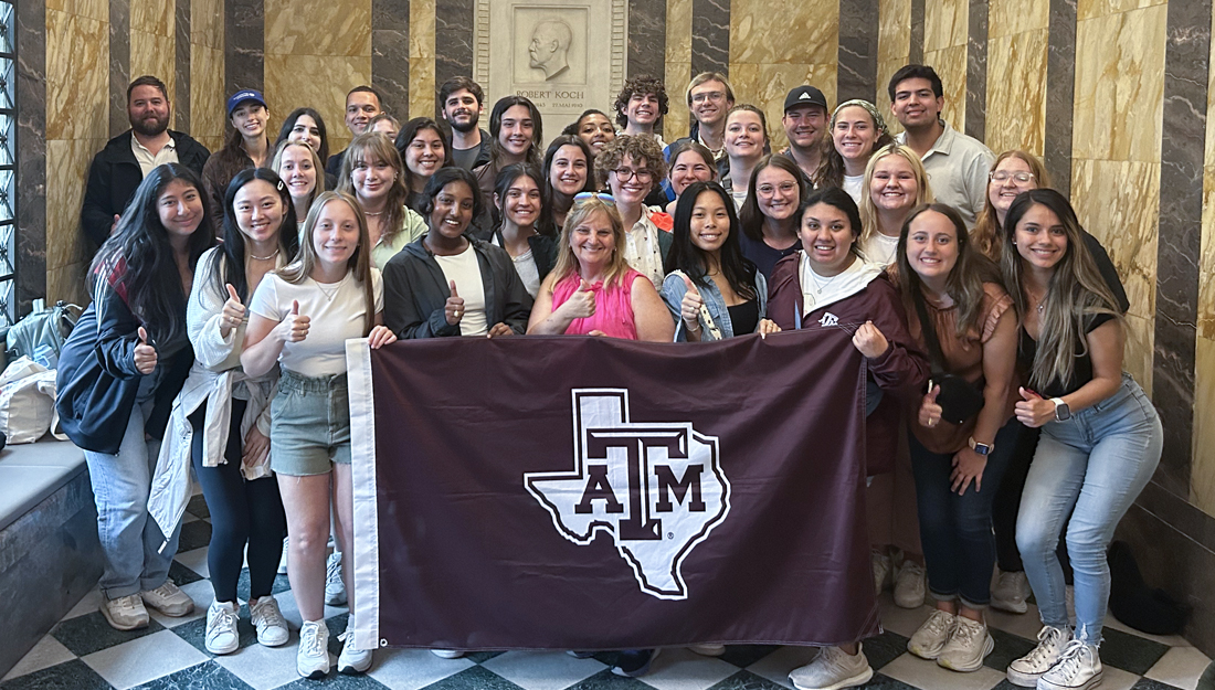 SPH study abroad students holding Texas A&M banner