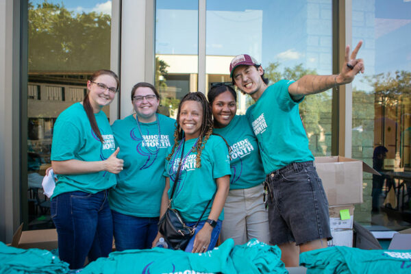 Group Of People Wearing Teal Suicide Awareness Month T-shirts Pose For A Photo Together