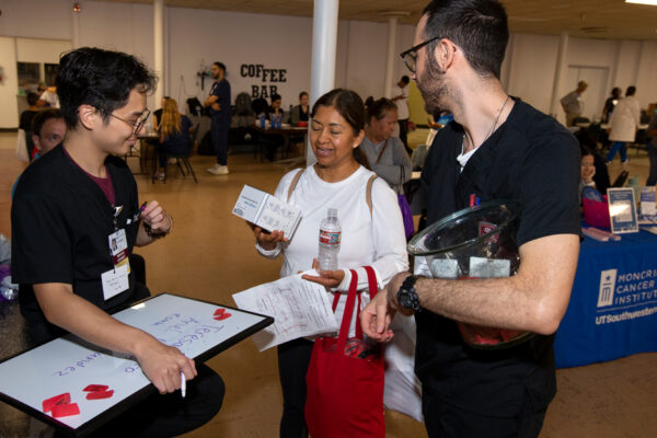 Two Medical Students Speak With A Health Fair Participant