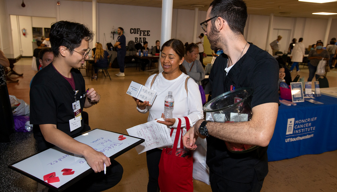 two medical students speak with a health fair participant