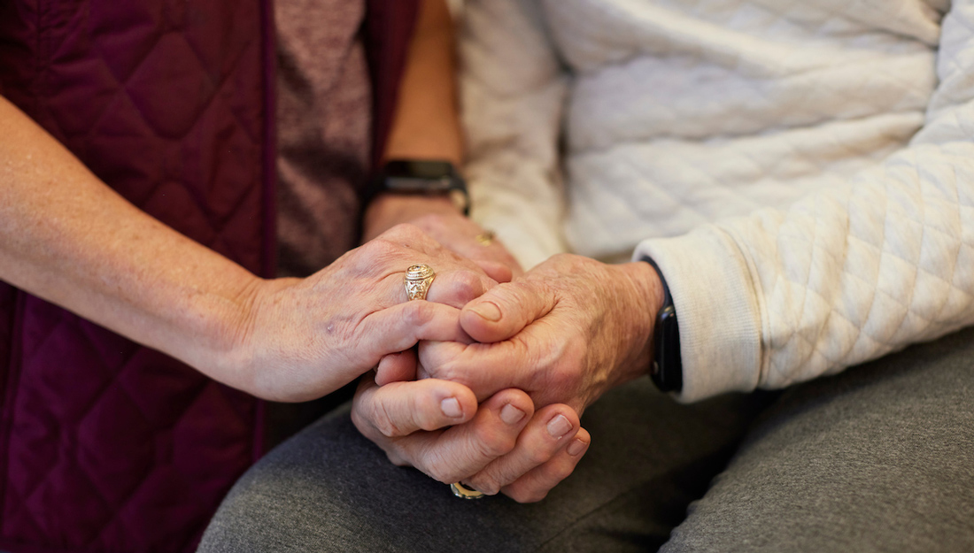 woman wearing Aggie ring holds hands of an older woman