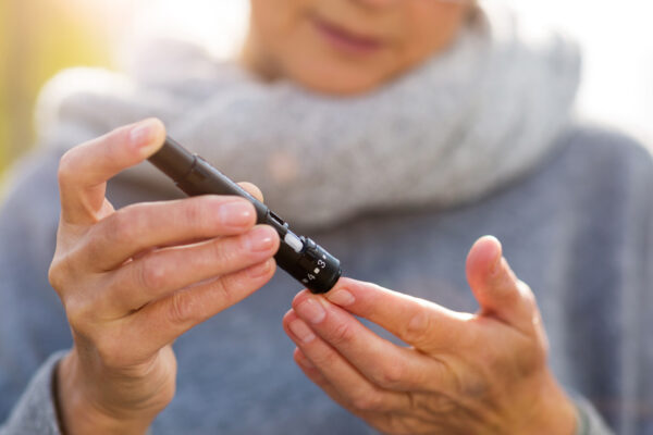 Woman Pricks Finger For Blood Glucose Check