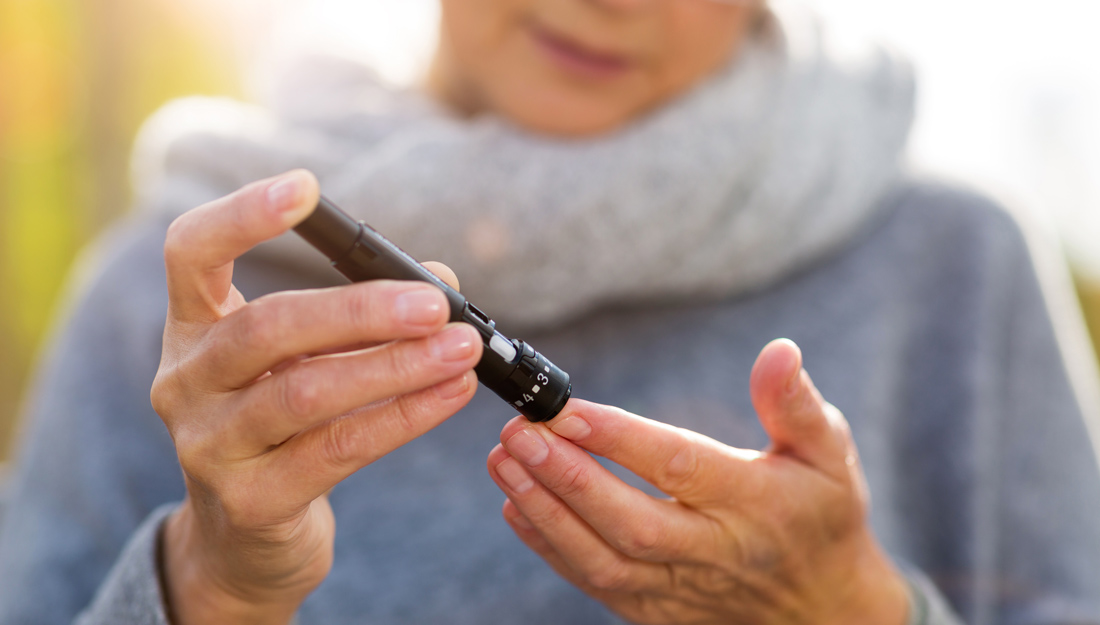 woman pricks finger for blood glucose check