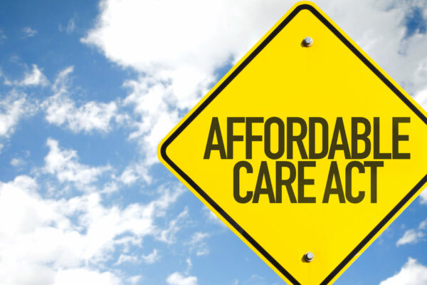 Affordable Care Act Sign With Sky Background; Rural And Urban ACA