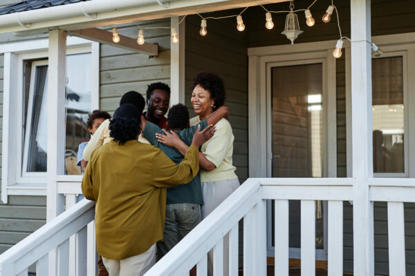 Black Family Embracing By House