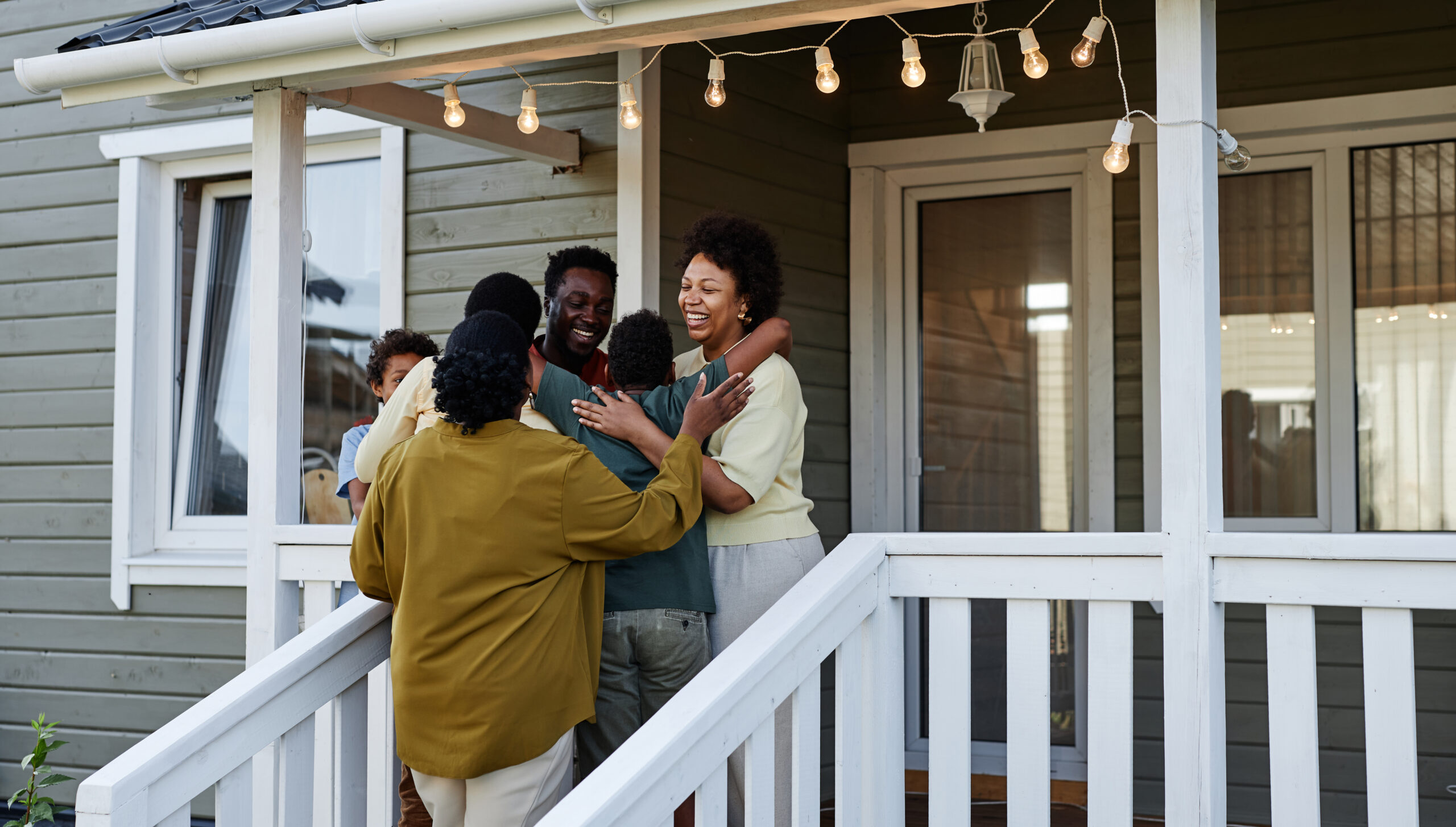 Black Family Embracing By House