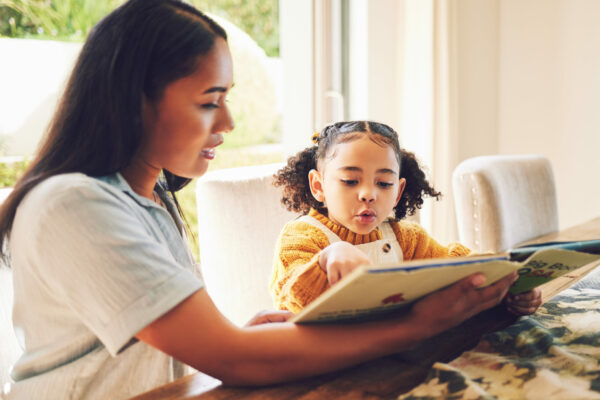 Mother Reads A Book To Her Young Child