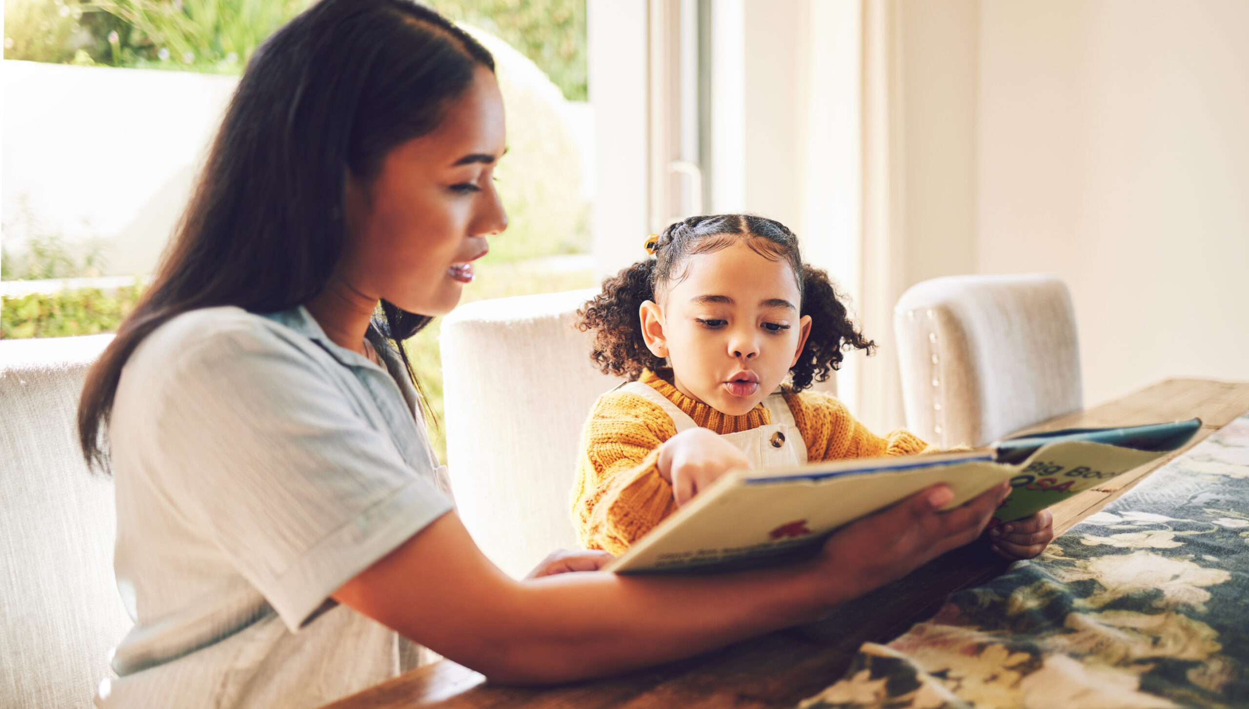 mother reads a book to her young child