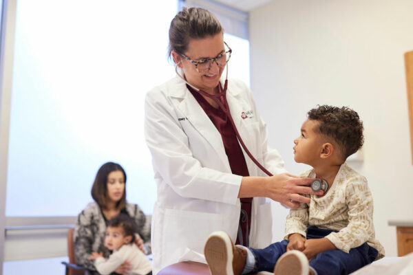 Physician Checks Pediatric Patient's Heart Sounds In A Clinic Exam Room