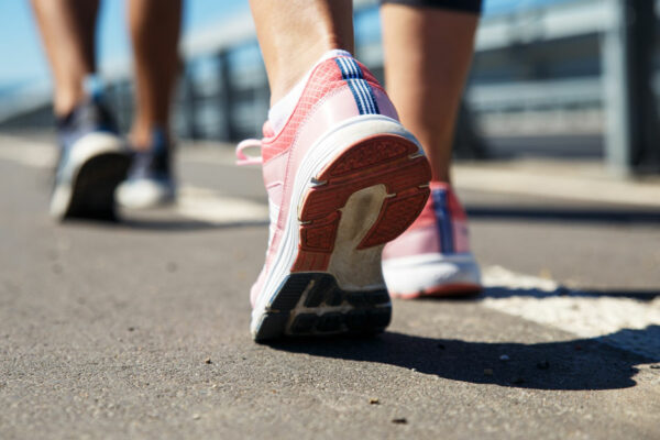 Feet Of A Couple Running On A Pathway