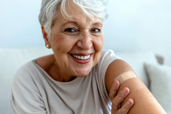 Vaccinated Woman With Bandage On Arm - COVID-19 Vaccines