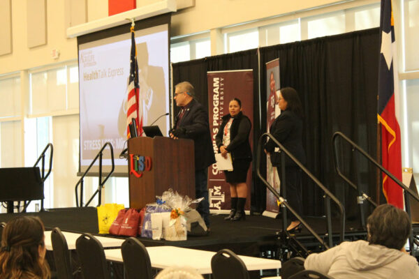 People Presenting On Stage At A Community Event