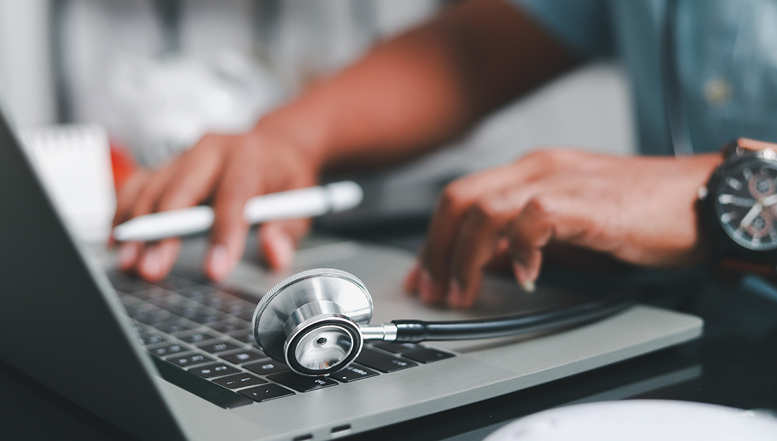 Student with stethoscope at laptop