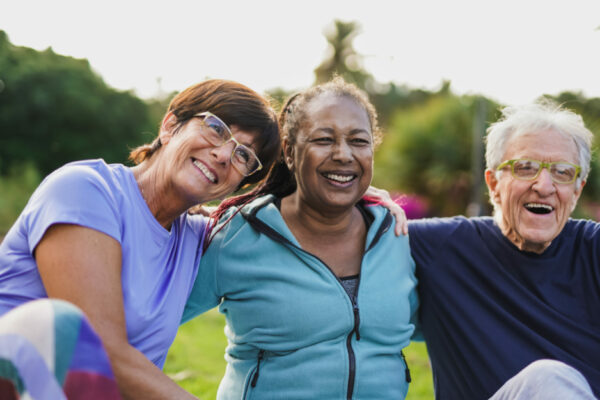 Happy Elderly People Having Fun Hugging Each Other Outdoors After Exercise