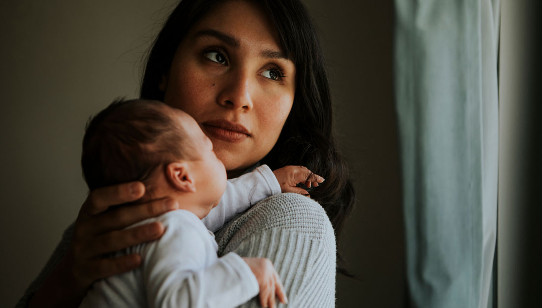 Mother holding her newborn baby indoor