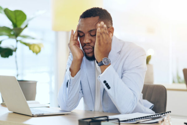 Business Man, Headache And Pain On Computer For Office Planning, Human Resources Crisis And Mistake Or Payroll Error. African Worker Or Employee With Fatigue, Tired And Stress For News Or Career Fail