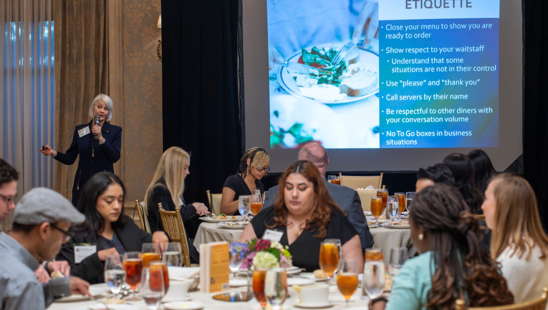 Dee-Anna Green presents to a group of students seated at dinner tables