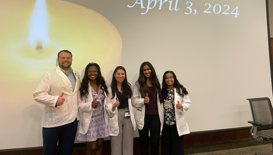 A group of 5 students in while coats pose for a photo during the Donor Memorial Ceremony