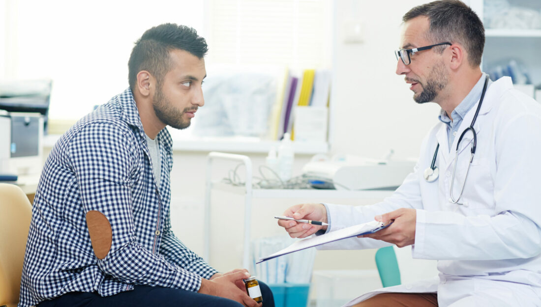 man visits with doctor in a clinic exam room