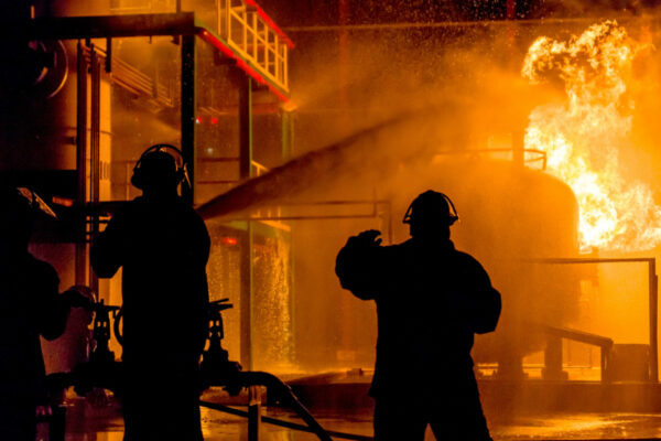 Firemen Using Water From Hose For Fire Fighting