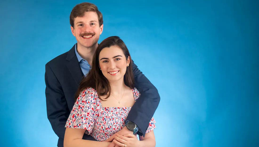 a young couple with arms around each other pose for a photo