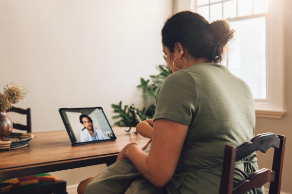 Woman Having Telemedicine Appointment At Dining Room Table