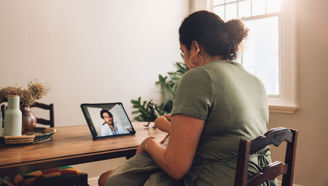 woman having telemedicine appointment at dining room table