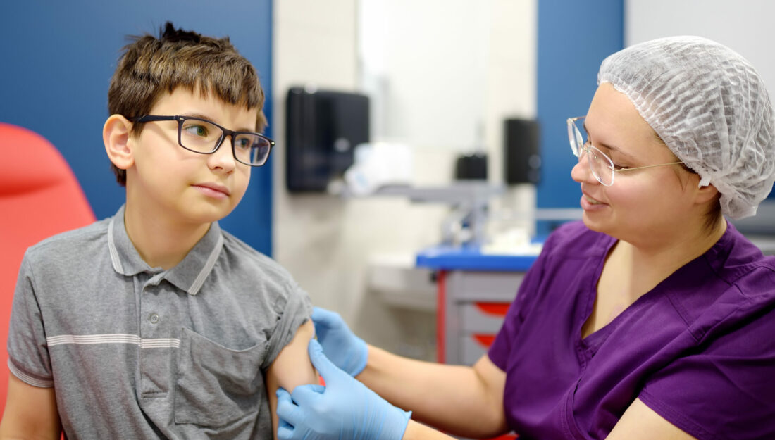 A little boy is being vaccinated. A child is very afraid of the injection. Schoolkid nervous during scheduled vaccination. Close up