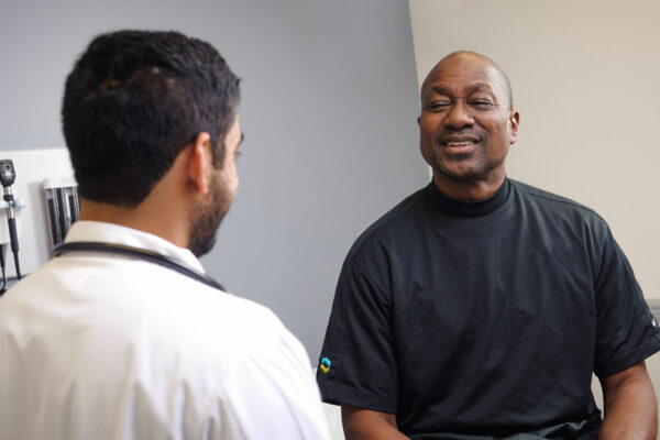 Man Talks With Physician In An Exam Room