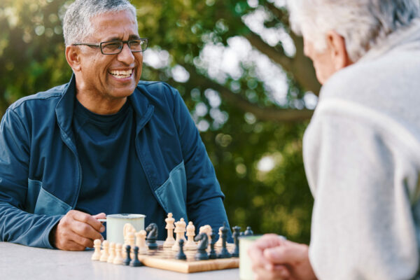 Two Older Men Play Chess Together Outdoors