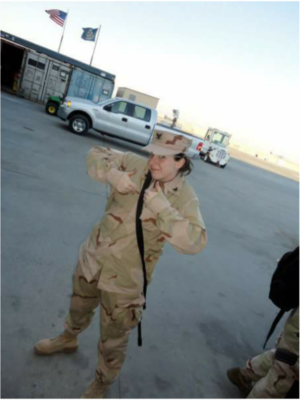 Sarah Ingram, in a Navy BDU uniform, holds up both her thumbs 