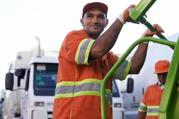 Cropped Shot Of A Team Of Solid Waste Workers On A Garbage Collection Vehicle