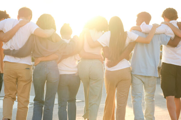 Group Of Students Walking Together In Line With Arms Around Each Other's Shoulders