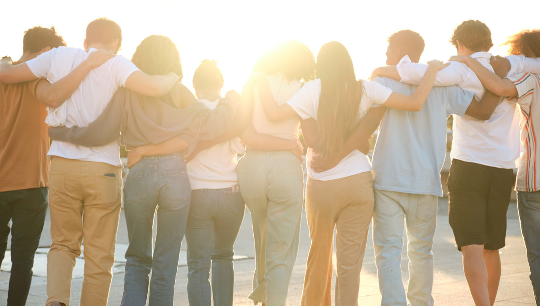 Group of students walking together in line with arms around each other's shoulders