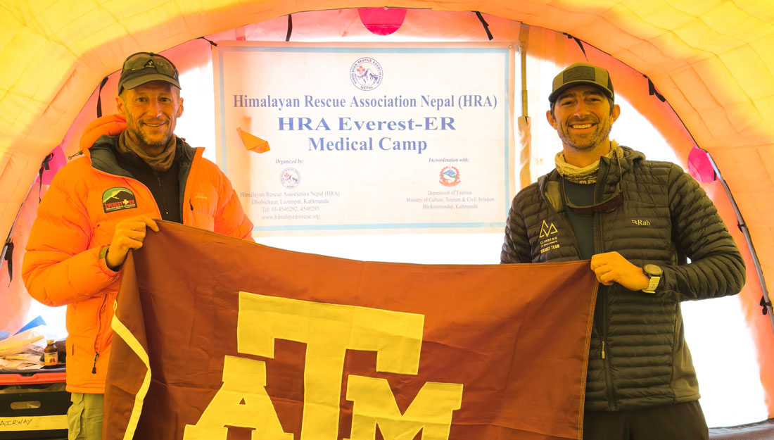 Two men hold a Texas A&M flag at the Mount Everest Base Camp