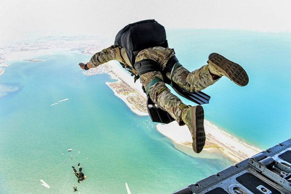 Pat Monday, wearing military BDUs, jumps out of an airplane